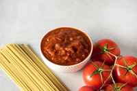 Pasta-spaghetti-with-raw-tomatoes-bowl-with-sauce-bolognese-gray-background-horizontal-copy-space_255585-3345